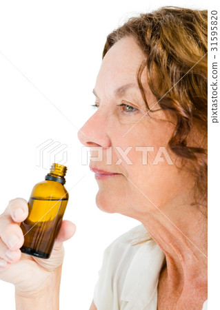 Close-up of thughtful mature woman smelling medicine 31595820