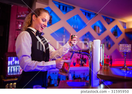 Barmaid pouring beer in glass 31595950