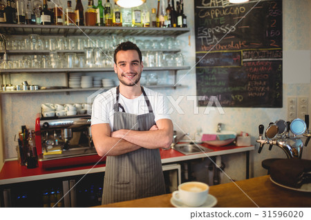 Portrait of confident barista with arms crossed at coffee house Portrait of confident barista with arms crossed at coffee house 31596020