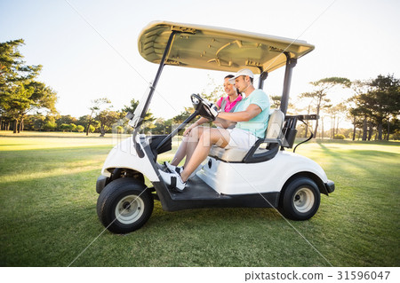 Golfer couple sitting in golf buggy 31596047