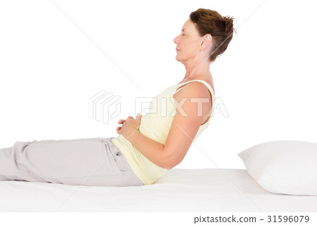 Side view of mature woman exercising on bed Side view of mature woman exercising on bed 31596079