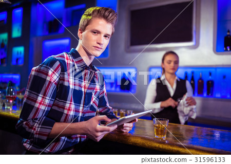 Portrait of man using digital tablet with bartender working Portrait of man using digital tablet with bartender working 31596133