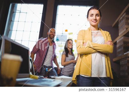 Confident businesswoman with colleagues in background 31596167
