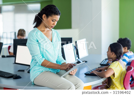 Female teacher using digital tablet Female teacher using digital tablet 31596402