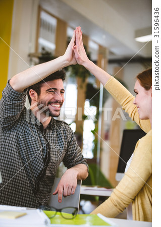 Colleagues giving high-five 31596436