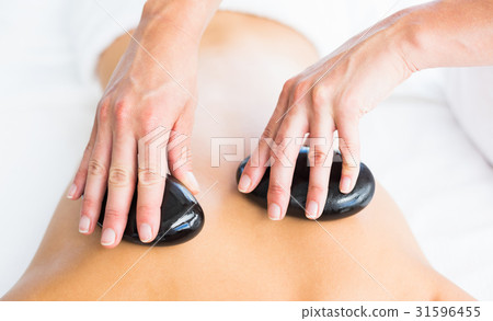 Cropped image of masseur giving hot stone massage on woman back 31596455