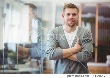 Portrait of happy businessman with arms crossed in office 31596478