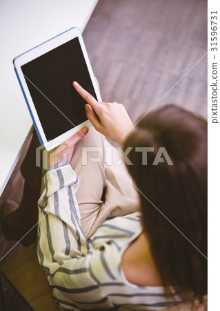 High angle view of executive touching tablet screen at office High angle view of executive touching tablet screen at office 31596731