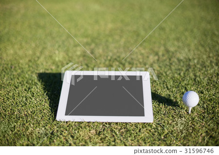Close-up of golf ball on tee by digital tablet 31596746