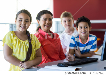 Teacher with children in computer room 31596762