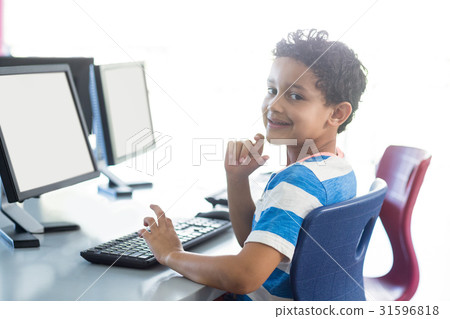 Smiling boy using computer Smiling boy using computer 31596818