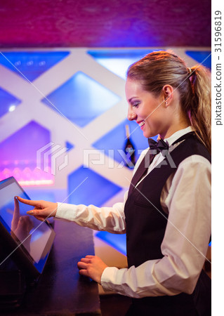 Barmaid smiling while using modern cash register 31596819