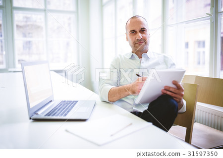 Businessman writing on document 31597350
