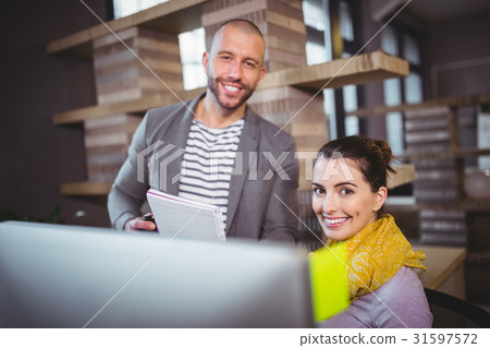 Happy colleagues working at computer desk 31597572