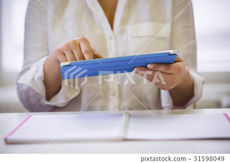 Midsection of executive using digital tablet at office Midsection of executive using digital tablet at office 31598049