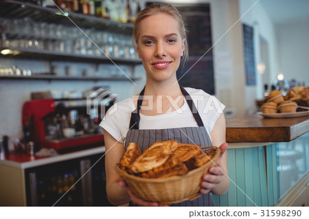 Portrait of confident waitress serving breads at coffee house 31598290