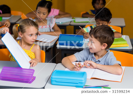 Girl showing book to classmate Girl showing book to classmate 31599234