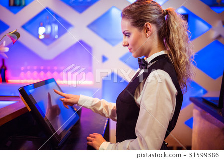 Barmaid using modern cash register at bar counter 31599386