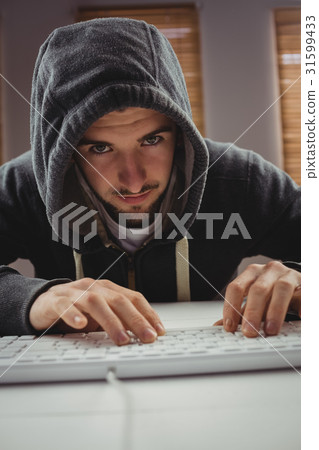 Portrait of young man using computer keyboard 31599433