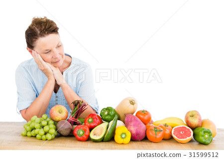 Thoughtful woman standing by fruits and vegetables Thoughtful woman standing by fruits and vegetables 31599512