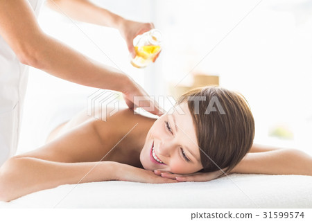 Masseur pouring massage oil on woman 31599574