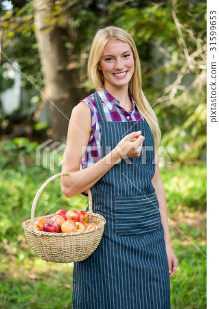 Portrait of happy gardener holding apples basket at garden Portrait of happy gardener holding apples basket at garden 31599653