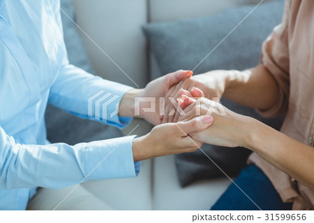 Midsection of therapist holding patient hands 31599656
