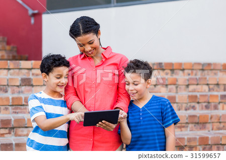 Teacher with students using digital tablet 31599657
