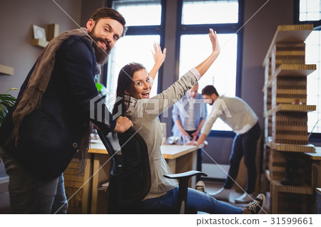 Happy coworkers enjoying by desk in creative office Happy coworkers enjoying by desk in creative office 31599661