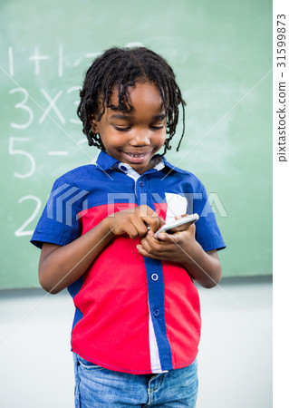 Boy using mobile phone in classroom 31599873