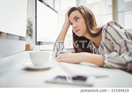 Businesswoman looking at computer in creative office 31599929