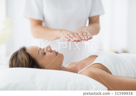 Young woman receiving reiki treatment Young woman receiving reiki treatment 31599938