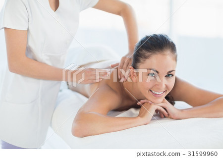 Portrait of smiling woman receiving back massage Portrait of smiling woman receiving back massage 31599960
