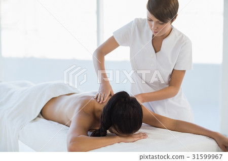 Masseuse giving massage to woman Masseuse giving massage to woman 31599967