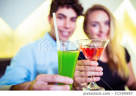 Smiling couple holding cocktail glasses 31599997