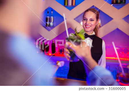 Young barmaid serving drink to male costumer 31600005