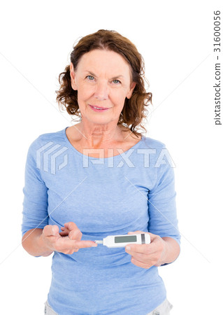 Portrait of smiling mature woman using blood glucose monitor 31600056