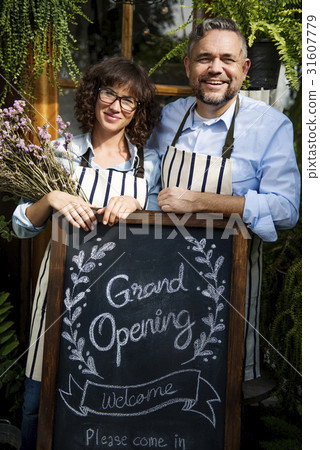 Adult Man and Woman Standing with Grand Opening Sign 31607779