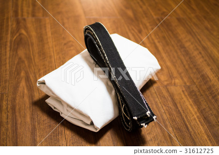 A black belt that was worn out with a dojo (karate arrival, judo arrival) placed on the dojo floor 31612725