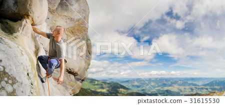 Male climber climbing big boulder with rope Male climber climbing big boulder with rope 31615530