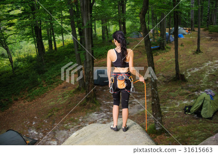 Female climber standing on boulder in the forest Female climber standing on boulder in the forest 31615663