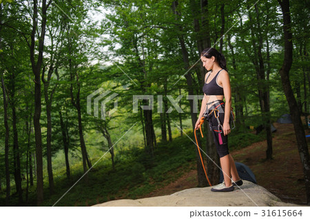 Female climber standing on boulder in the forest Female climber standing on boulder in the forest 31615664