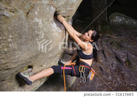 Female climber climbing big boulder with rope Female climber climbing big boulder with rope 31615665