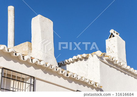 A roof scenery of a Spanish house with a blue sky and a chimney 31616684