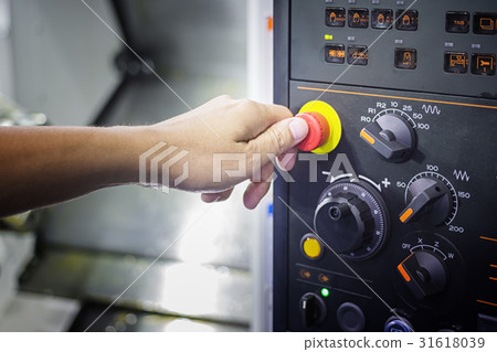 A Thumb ready to press emergency Stop button 31618039