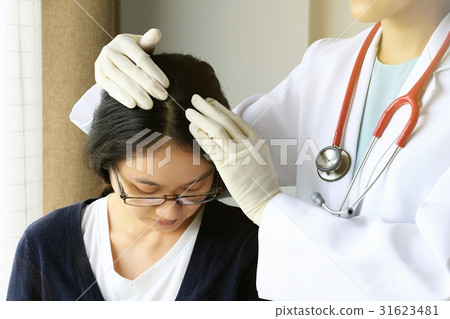 Female doctor looking at patient's hair and scalp 31623481