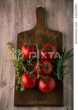 Few red cherry tomatoes on green branch with herbs Few red cherry tomatoes on green branch with herbs 31626903