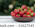 Ripe red strawberries on wooden table 31627545