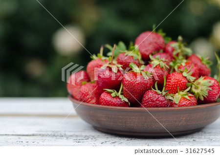 Ripe red strawberries on wooden table 31627545