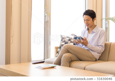 Men sit on couch in apartment, Male in twenties Men sit on couch in apartment, Male in twenties 31630046
